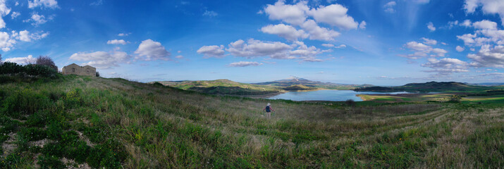 Fototapeta premium 360 degree aerial photo of Ogliastro lake in the heart of Sicily with Etna view. Place of great naturalistic value surrounded by hills planted with cereals. A destination for migratory bird species.