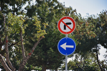 traffic signs standing in front of trees in the park