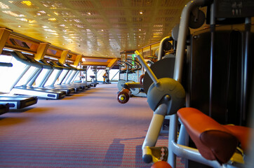 Staying fit with weight and cardio fitness equipment and machines in gym or fitness center on...