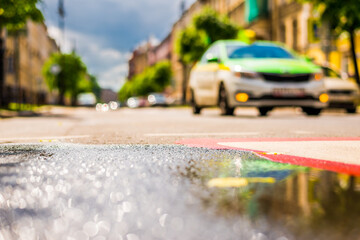 Sunny day after rain in the city, road with markings on which the car rides. Close up view from the...