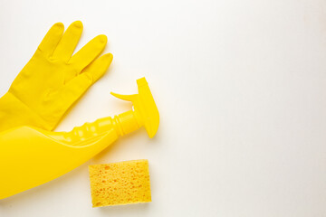 Plastic bottles of cleaning products, sponge and glove on white background with space for inscription