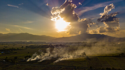 Aerial view. The morning sunrises with dry grass is burning on the field. Burning old chaff on the farmland.