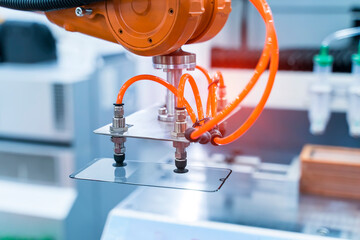 Industrial robot with vacuum suckers picks the mibile item from the conveyor in manufacture factory