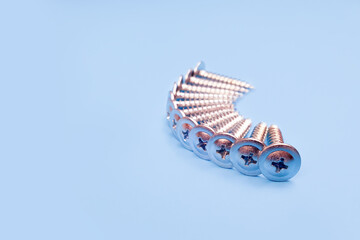 Fototapeta premium screws macro photo. Long Iron or metal screw nails on blue backgraund. Front view.