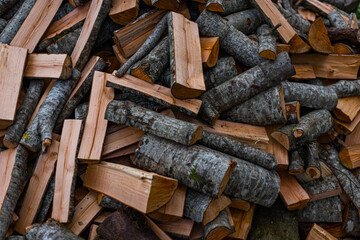 A large pile of sawed and split firewood. Harvesting firewood for the fireplace, campfire, grilling, smoking meat or for other purposes. selective focus