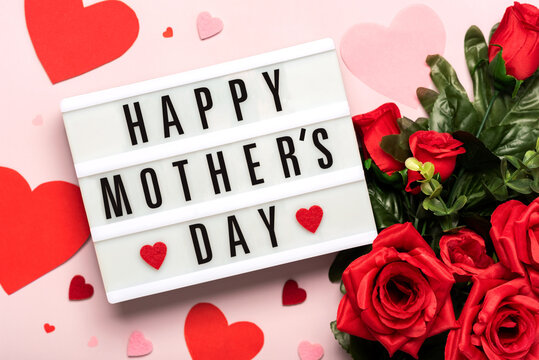 Happy Mother's Day.Lightbox with the word Happy Mother's Day next to hearts and bouquet of red red roses