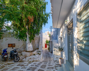 Beautiful traditional narrow cobbled streets of Greek island towns. Whitewashed houses, scooters, flower pots, balconies, stairs. Mykonos, Greece