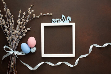 Easter greeting card with quail eggs in nest on wooden background. Top view flat lay with space for your greetings