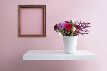 Room interior with blank picture frame and flowers