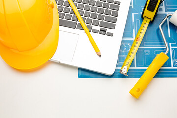 Floor plan, hard hat, roller, tape measure, pencil on a white background with space for inscription