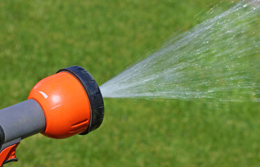 Closeup of the water garden sprinkler and splashing water in summer 