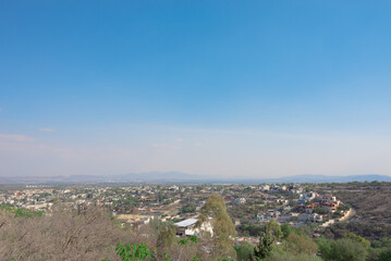 view of a poor village from a mountain, the blue and cloudy sky in the distance