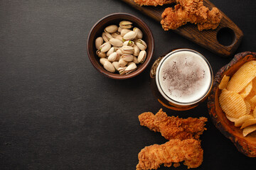 bottle of beer and different snacks on rustic wooden table. Top view