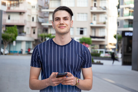 Portrait Of Young Handsome Man Of Arabic Ethnicity On The City Streets. Iranian Guy Over With Hipster Hairstyle Wearing Casual Attire. Close Up, Copy Space For Text.