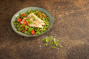 Alaska pollock fillet with steamed green beans on a rusty metal background