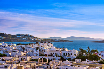 Famous tourist attraction of Mykonos, Greece. Beautiful sunset over traditional whitewashed windmills. Travel destination, iconic view.