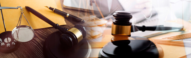 Justice and law concept.Male judge in a courtroom with the gavel, working with, computer and docking keyboard, eyeglasses, on table in morning light