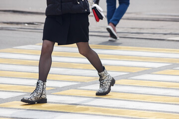 Obraz premium pedestrians cross the street at a pedestrian crossing