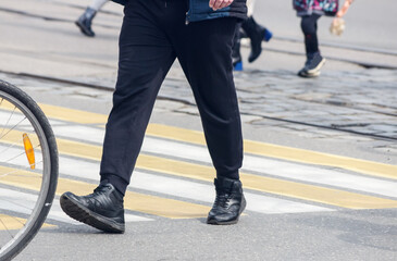 Obraz premium pedestrians cross the street at a pedestrian crossing