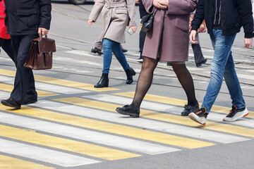 pedestrians cross the street at a pedestrian crossing