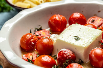 Close up fetapasta, oven baked cherry tomatoes and feta cheese with olive oil and thyme, Food recipe background