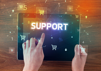 Close-up of a hand holding tablet with shopping inscription