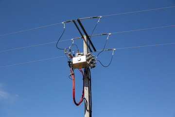 Electrical pylon with high voltage transformer on blue sky