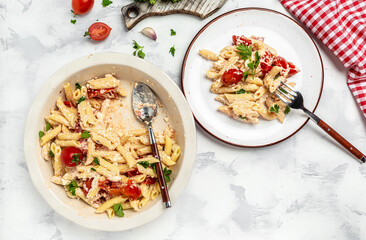 Fetapasta with roasted cherry tomatoes, cheese, herbs and garlic on white plate. menu recipe place for text, top view