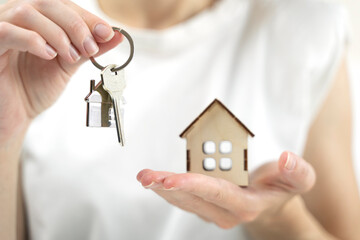 the key to your own home in the palm of the girl and a wooden house
