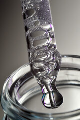 a cosmetic pipette filled with a bubbling liquid and a bottle. close-up.