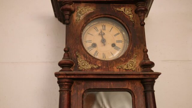 Broken antique mechanical wall clock that once showed the hour in room. Time measurement. Antique entourage. Close up