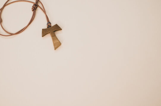 Top view of a wooden tau cross necklace isolated on a white background
