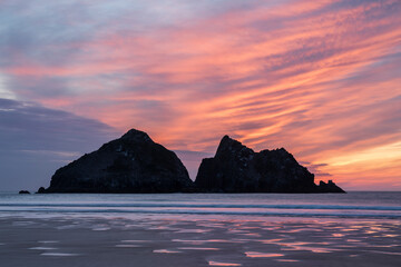 Absolutely stunning landscape images of Holywell Bay beach in Cornwall UK during golden hojur sunset in Spring