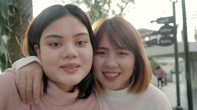 Young happy asian pretty girls couple friend blogger take selfie look at camera with smile face in the city street. Close up portrait funny joyful young women, Outdoor holiday vacation concept.