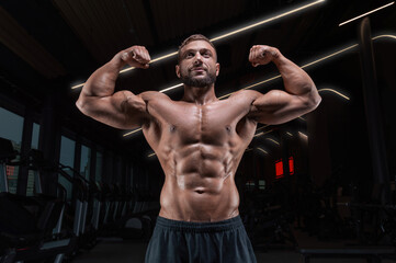 Muscular man posing in the gym. Fitness concept.