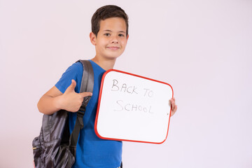 Beautiful young boy smiling holding a white board over white background