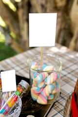 Naklejka na ściany i meble Jar with colorful marshmallows on decorated birthday table.