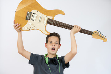 A young boy sings and plays on the electric guitar with bright emotions, isolated on white background