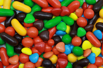 Bright rainbow background of small round candies of different shapes in a hard glaze. Many colorful close-up lollipops are sold by weight.Flat layout