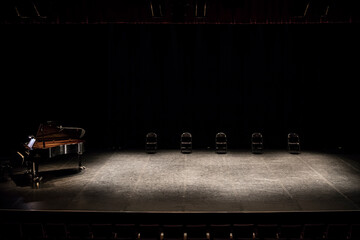 set stage in the theater with chairs and piano