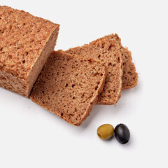 sliced rye bread on a white plate with  olives