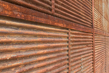 Porte de ferro com ferrugem e sem pintura.