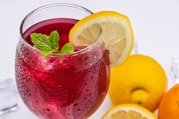 Refreshing cocktail (Red Summer Wine) on white methacrylate background. Concept of fun and social life in bars and pubs. Horizontal photo and selective focus