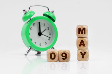 On a white background there is an alarm clock and a calendar with the inscription - MAY 09