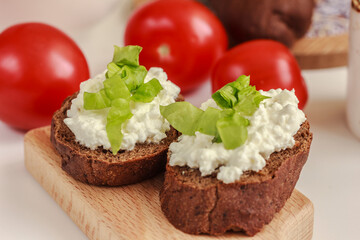 Healthy Open Rye Sandwiches with cottage cheese and green salad, tomatoes on the white background. Easy snack idea. Bio, organic, natural ingredient. Side view, stock photo