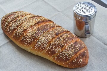 Loaf of homemade bread with seeds on linen fabric