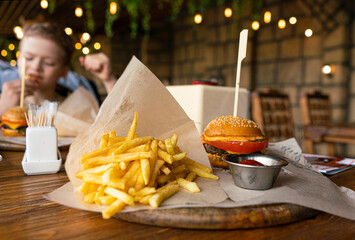 a child in a cafe eats a mini burger with fries. children's menu