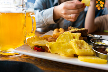 fresh light beer at the bar. beer snacks. chips and onion rings for beer