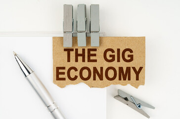 On a white background lies a notebook, a pen, clothespins and cardboard with the inscription - The...