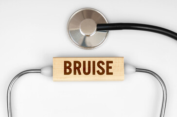 On the table is a stethoscope and a wooden plate with the inscription - BRUISE